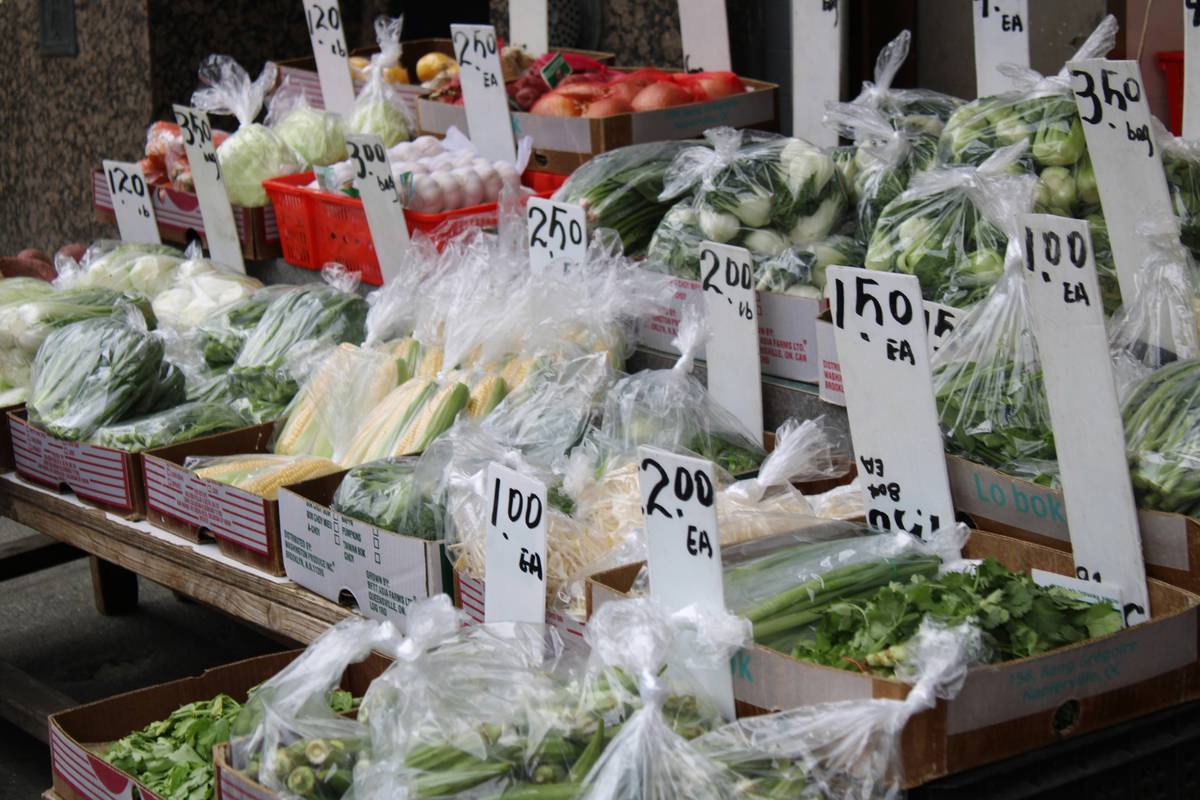 A close-up of scissors cutting out printed coupons from a newspaper