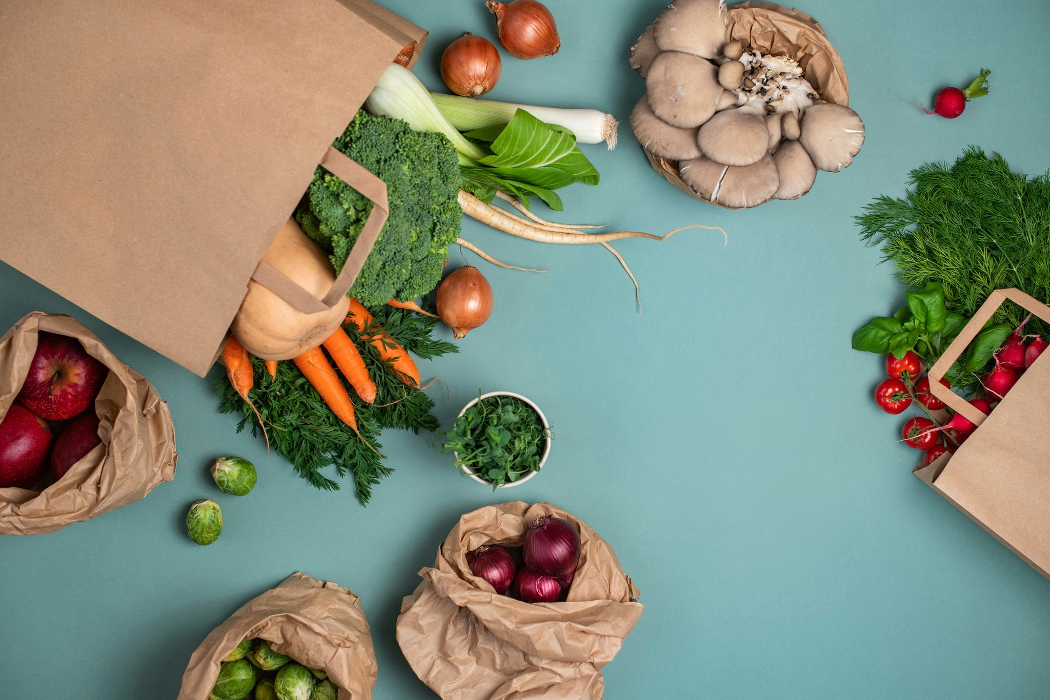 A colorful array of fresh vegetables and fruits arranged neatly on a wooden table, representing affordable health food choices.