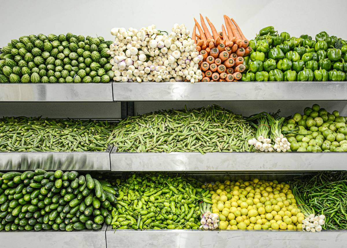 A person holding a basket of discounted organic fruits and vegetables