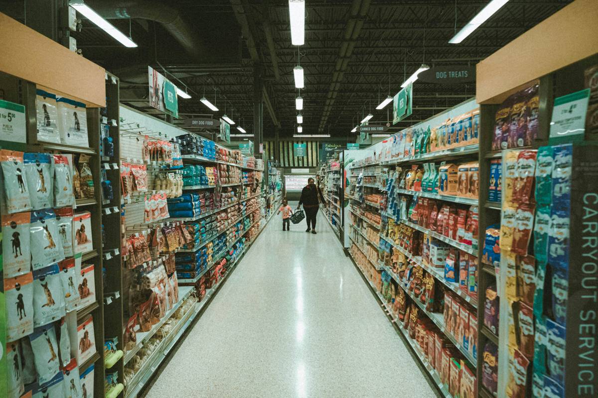 A shopping cart filled with discounted items including bread, milk, and snacks
