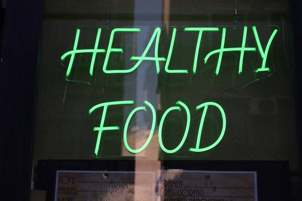 Man checking expiration dates on dairy products in a supermarket aisle