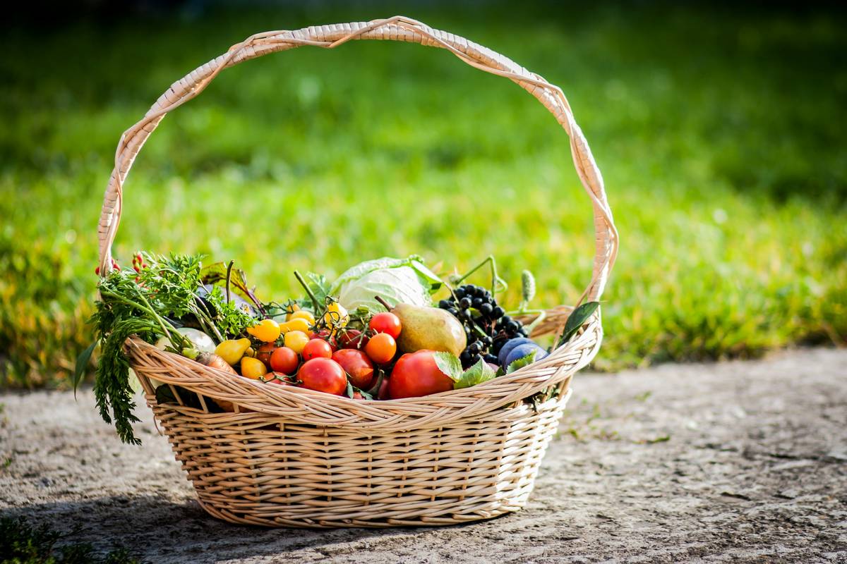 Woman happily selecting fresh produce from a budget-friendly market shelf