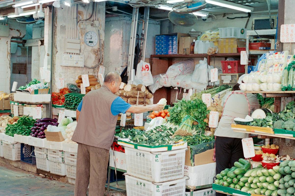 A colorful sign announcing 'Buy One Get One Free' offer on kale and spinach bundles.