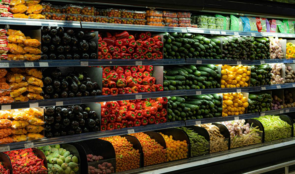 A vibrant shopping cart filled with fresh produce, nuts, and whole grains.