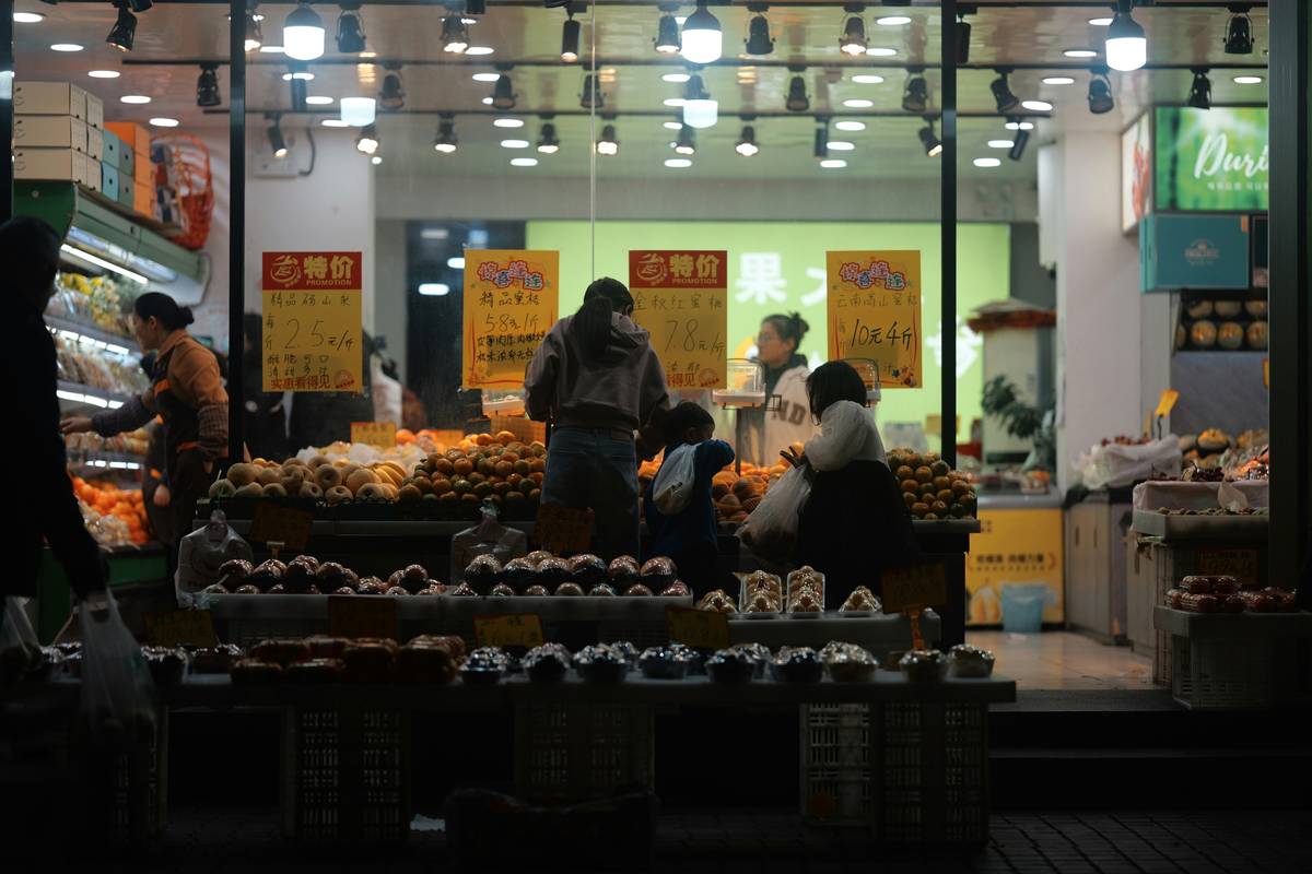 Person filling reusable bags with bulk bins of nuts and grains
