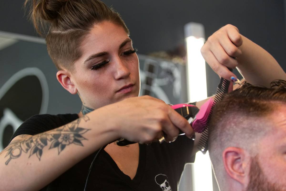 A barber woman with tattoos in Denver, CO