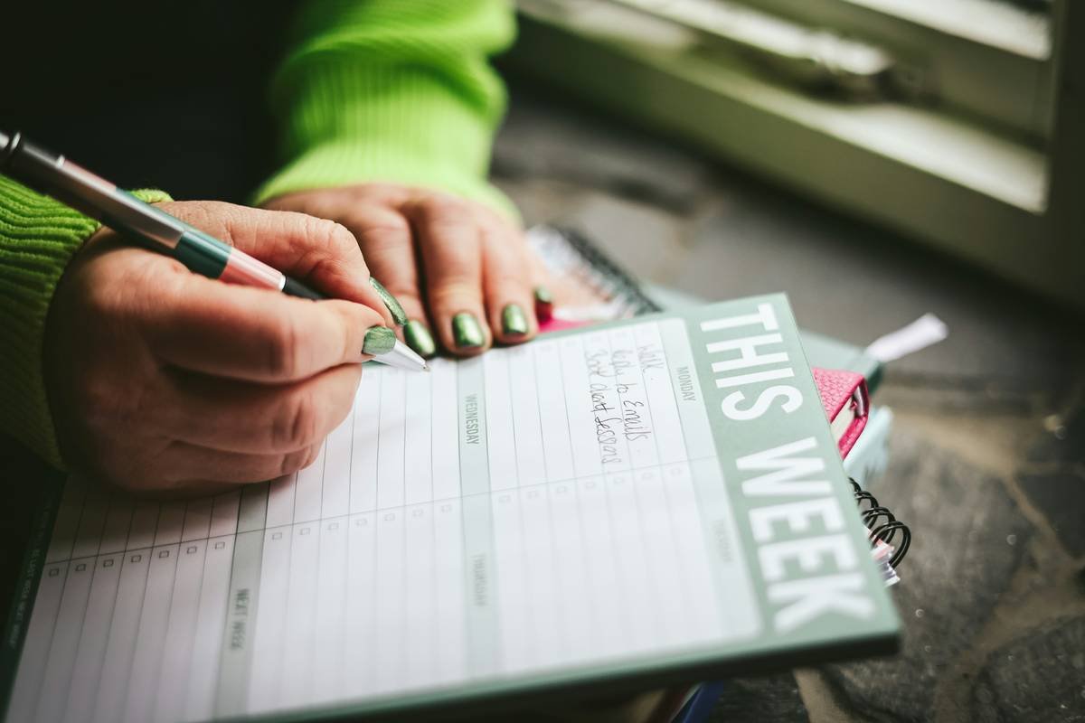 Female hands with green nail varnish writing her "to do" list