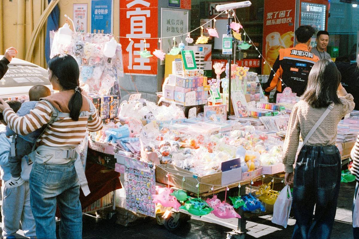 Woman comparing prices at steals budget tops friendly markets with reusable bags and notebook