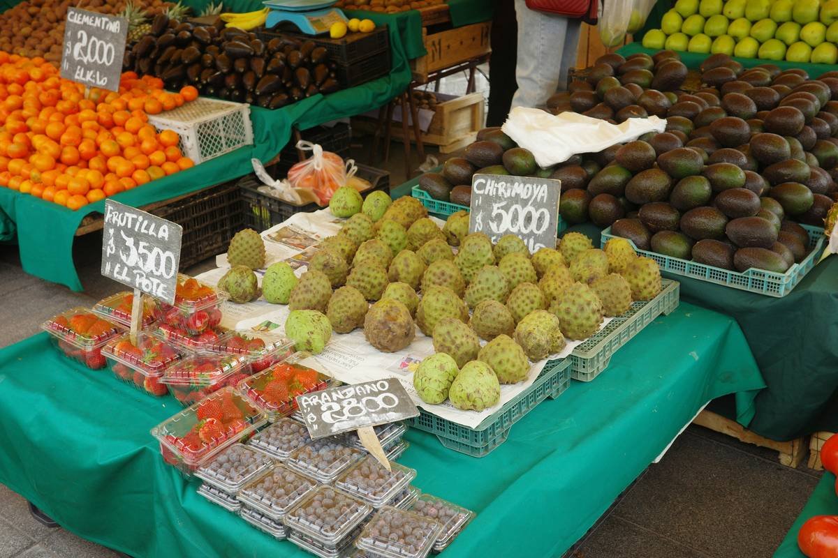 how to market produce: vibrant display of colorful fruits and vegetables arranged neatly on wooden crates with handwritten signs at a grocery store
